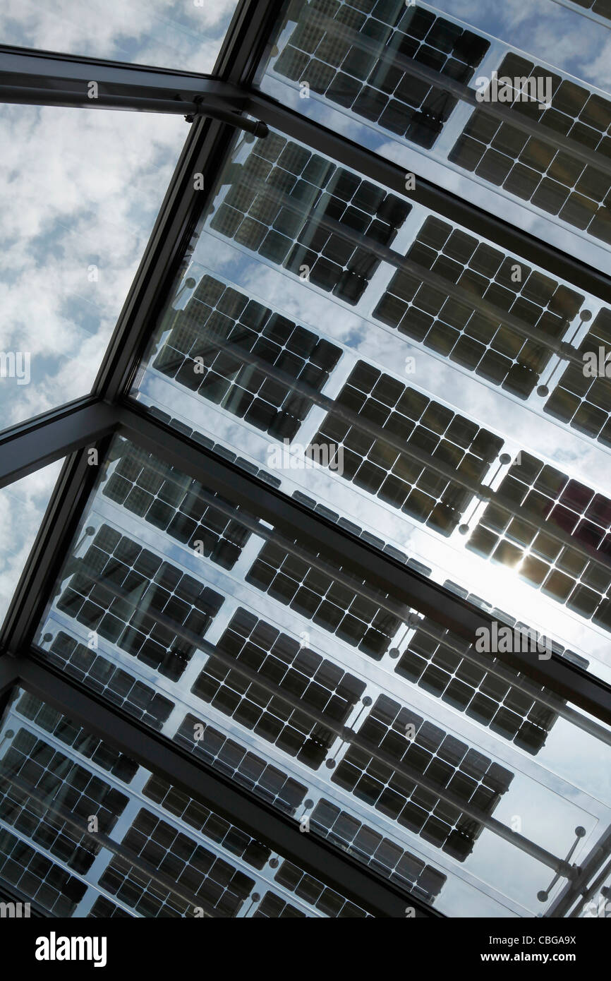 Unter einer Reihe von Sonnenkollektoren auf offenem Dach mit Himmel im Hintergrund Stockfoto