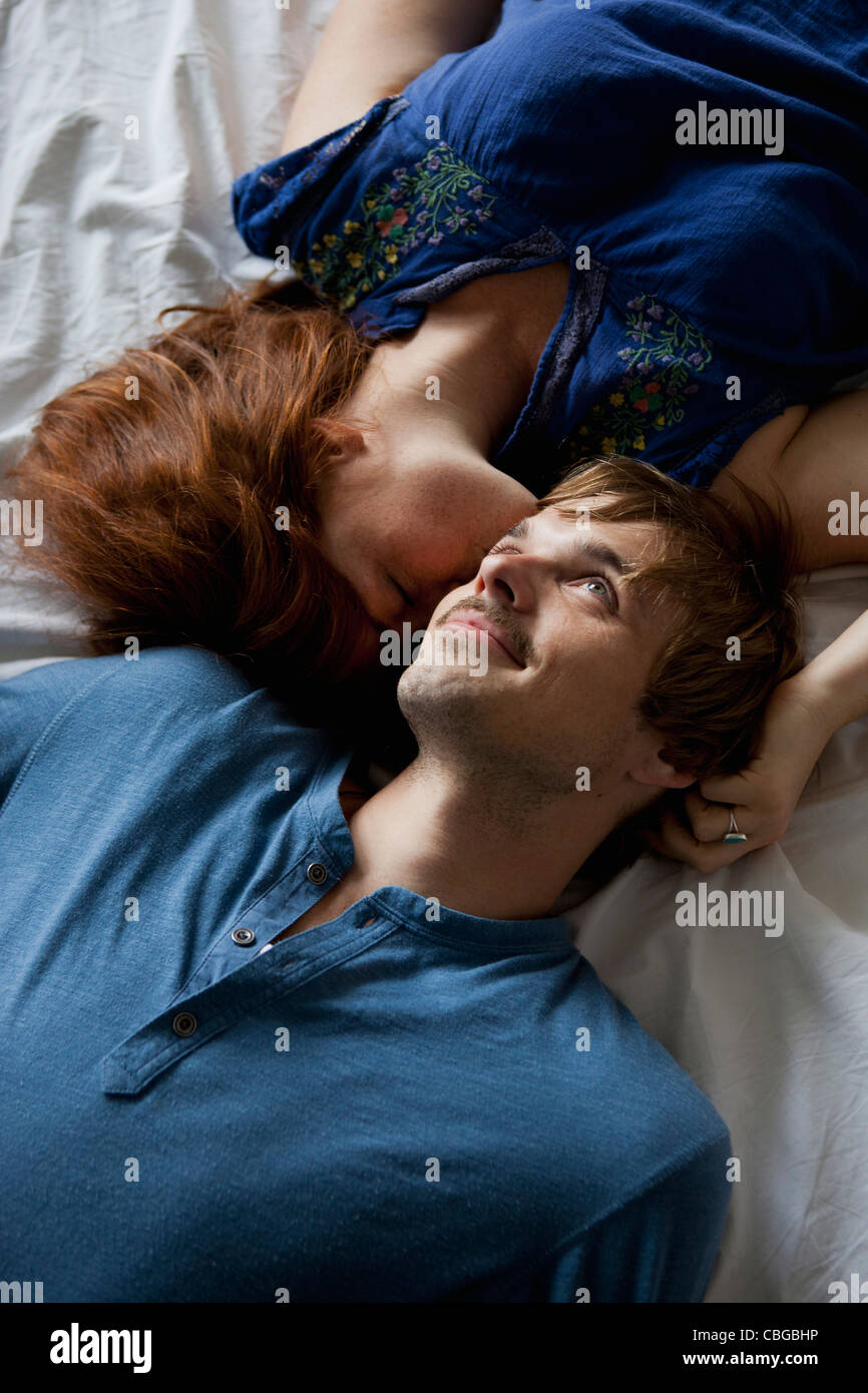 Ein junges Paar, Kopf an Kopf auf einem Bett liegend Stockfoto