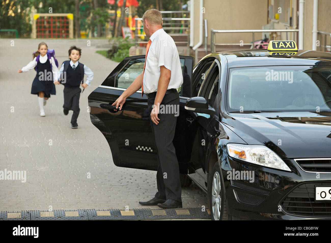 Zwei Kinder in Schuluniformen läuft auf schwarzen Taxi Stockfoto