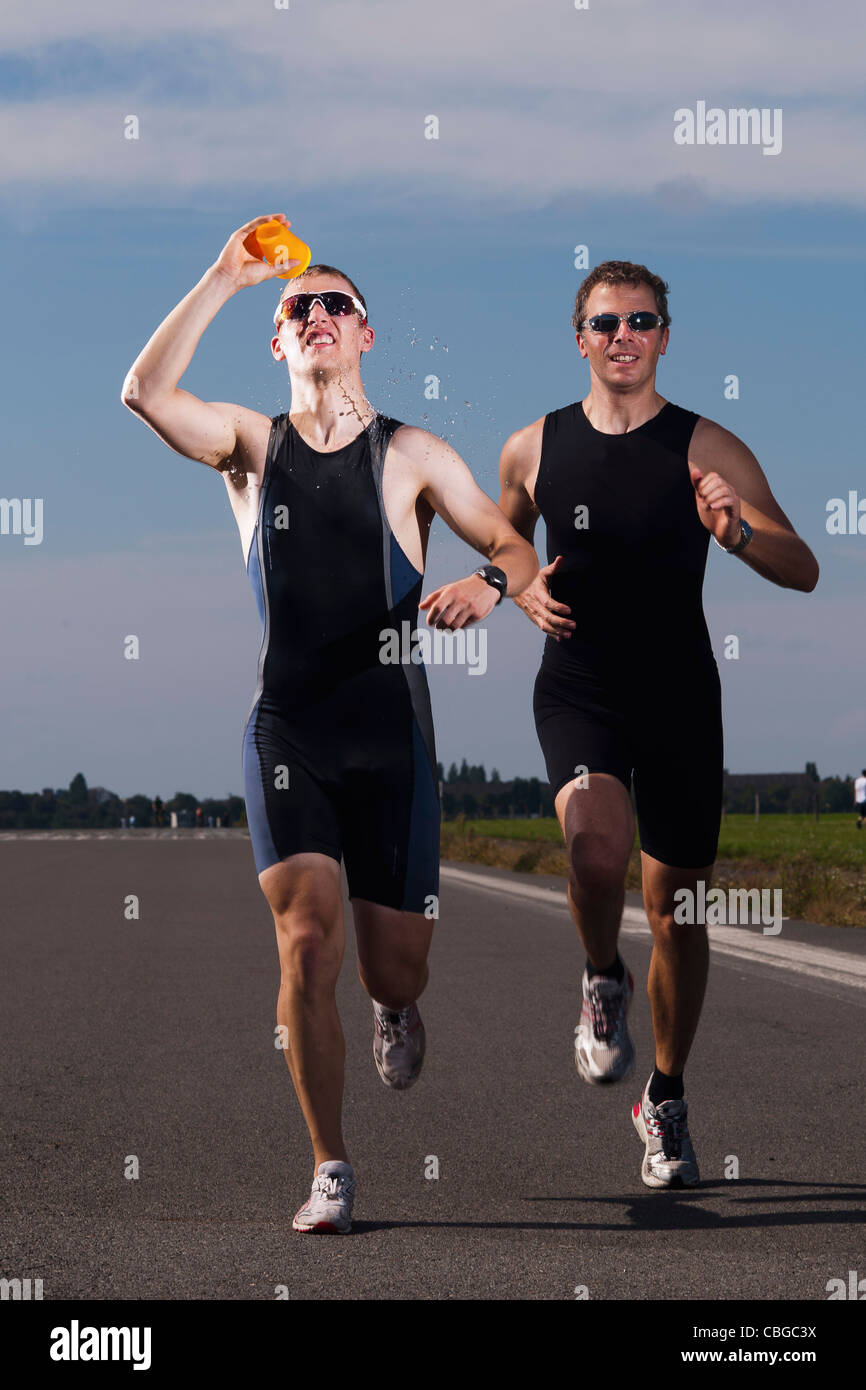Ein Läufer gießt Wasser auf seinem Gesicht während der Ausführung in einem Rennen Stockfoto