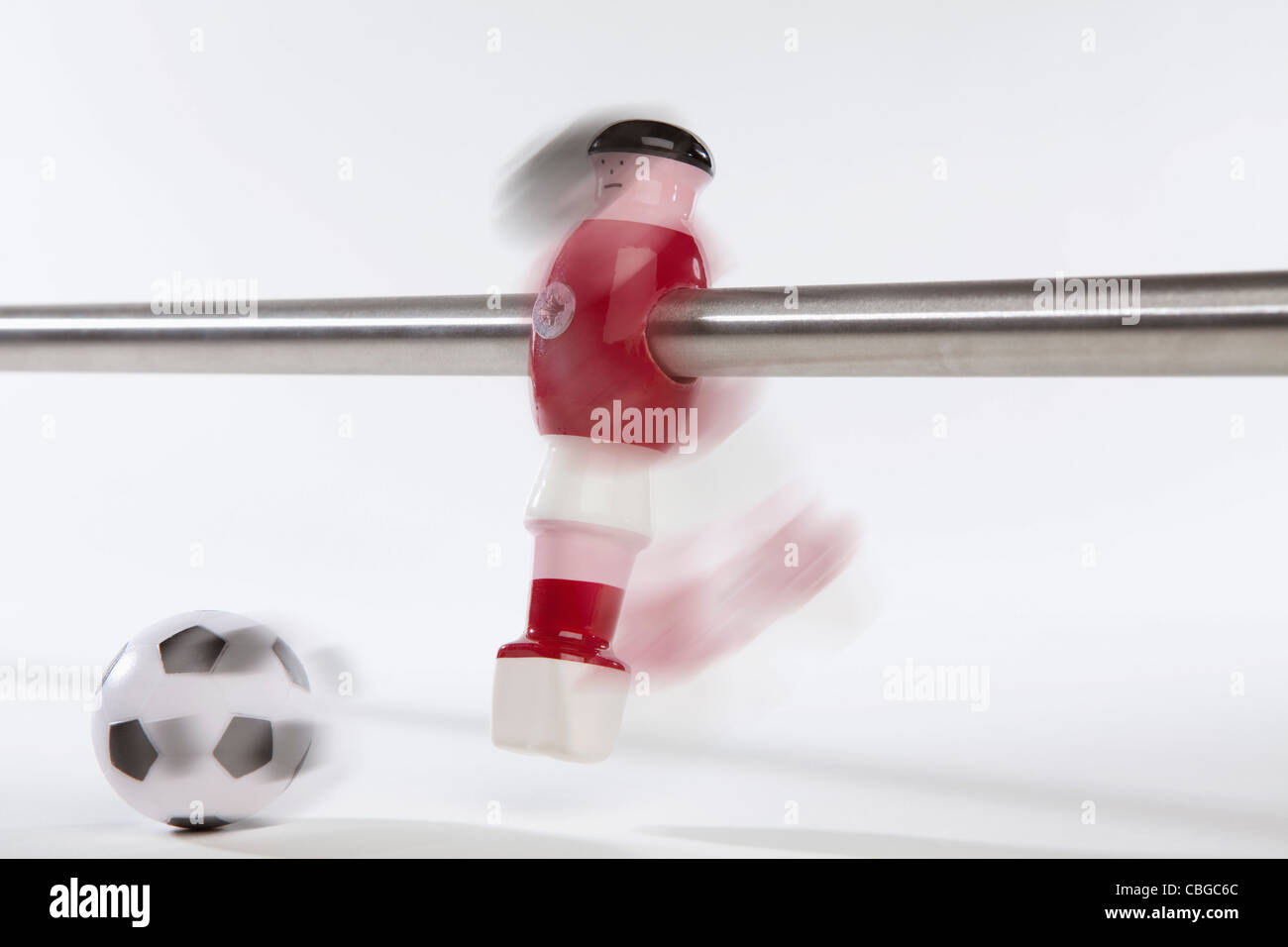 Ein Tischfußball-Figur treten eine Fußballkugel, Bewegungsunschärfe Stockfoto