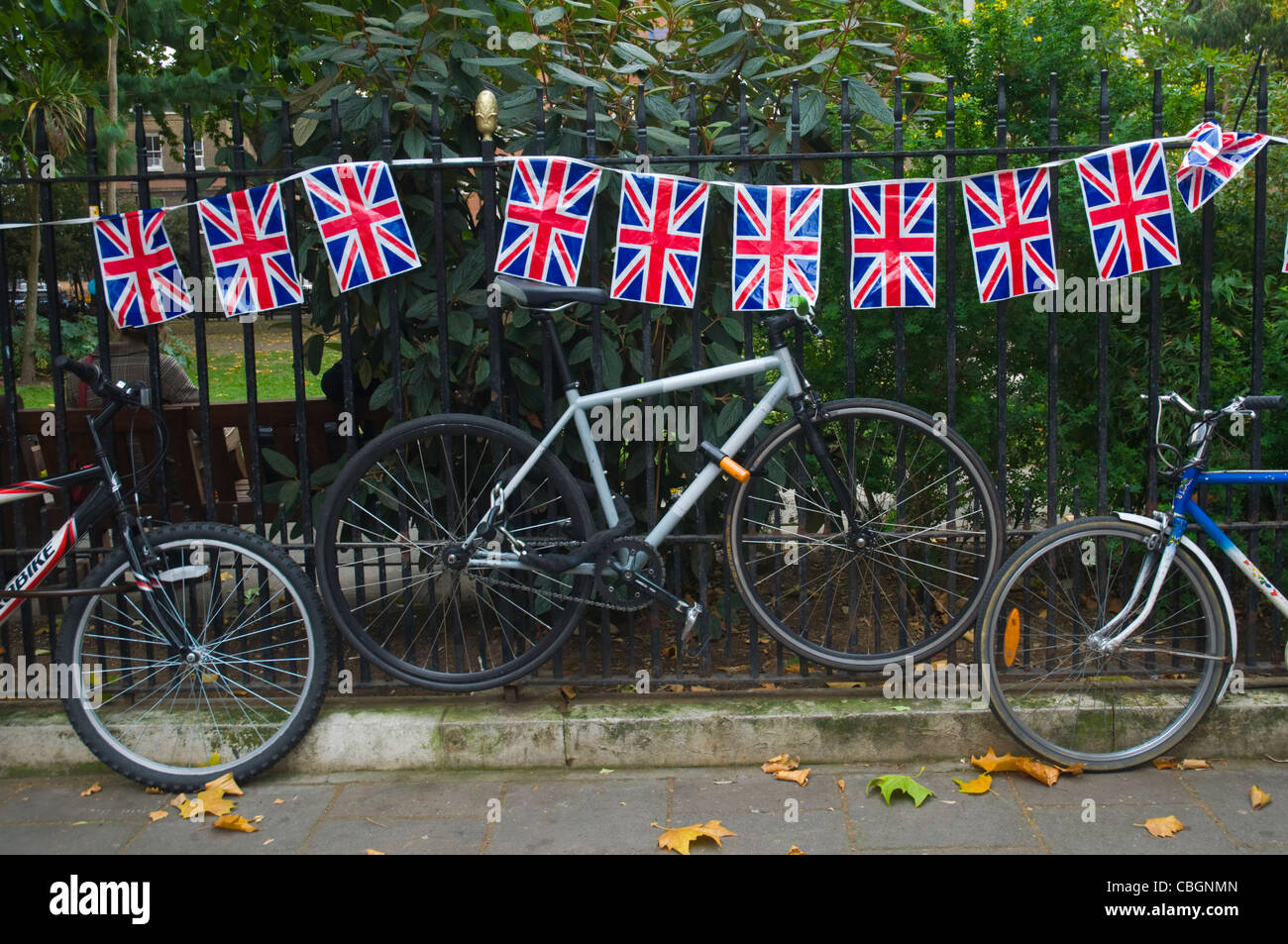 Union Jack-Flaggen und geparkte Fahrräder Soho Square London England UK Mitteleuropa Stockfoto