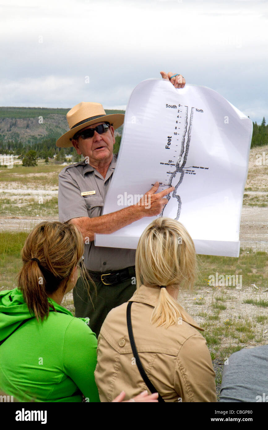 Parkranger, eine Tour Gruppeninformationen über Old Faithful Geysir im Yellowstone-Nationalpark, Wyoming, USA. Stockfoto