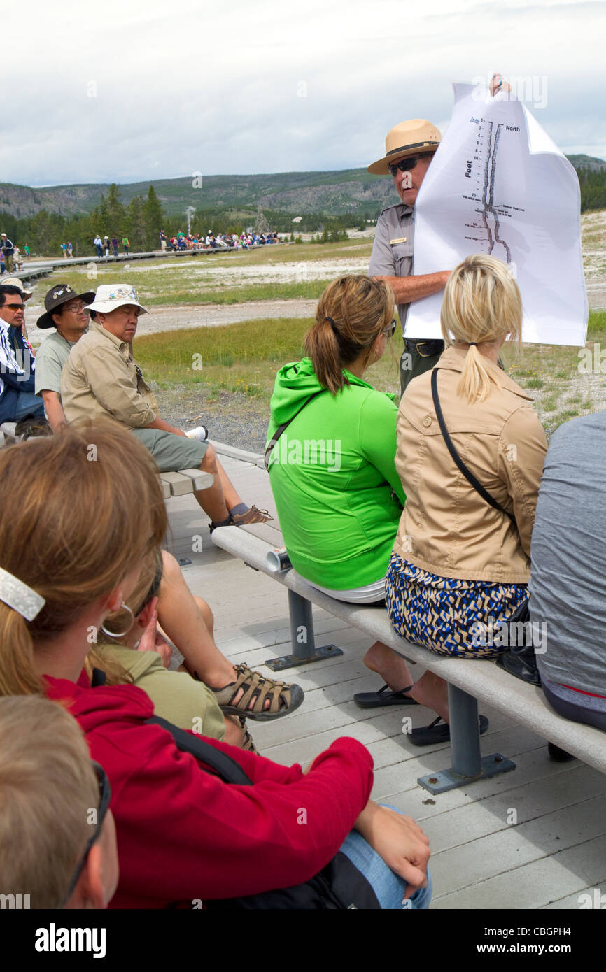 Parkranger, eine Tour Gruppeninformationen über Old Faithful Geysir im Yellowstone-Nationalpark, Wyoming, USA. Stockfoto