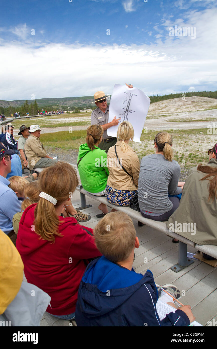 Parkranger, eine Tour Gruppeninformationen über Old Faithful Geysir im Yellowstone-Nationalpark, Wyoming, USA. Stockfoto