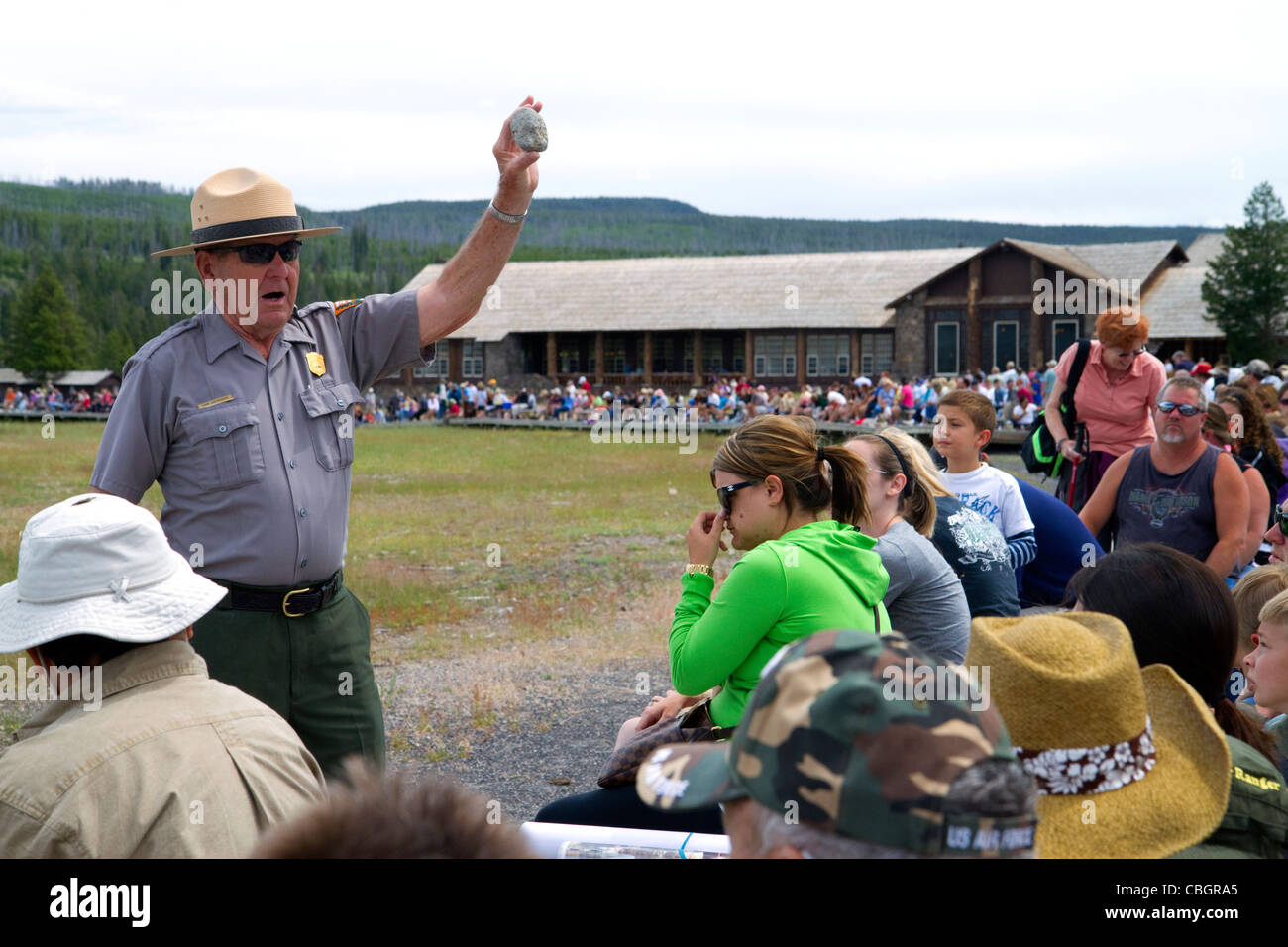 Parkranger, eine Tour Gruppeninformationen über Old Faithful Geysir im Yellowstone-Nationalpark, Wyoming, USA. Stockfoto