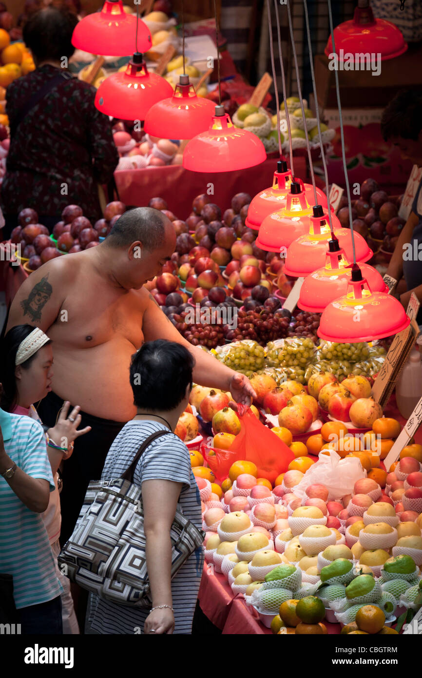 Große chinesische Mann am Obstmarkt in Hong Kong. Stockfoto