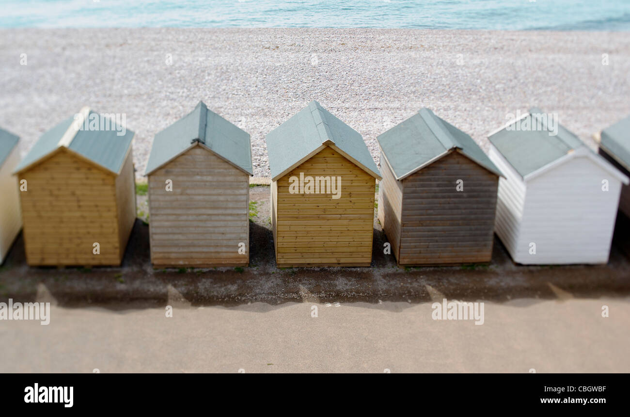 bunte hölzerne Strandhütten entlang der Strandpromenade in Budleigh Salterton, Devon auf ein Tilt-Shift-Objektiv genommen Stockfoto