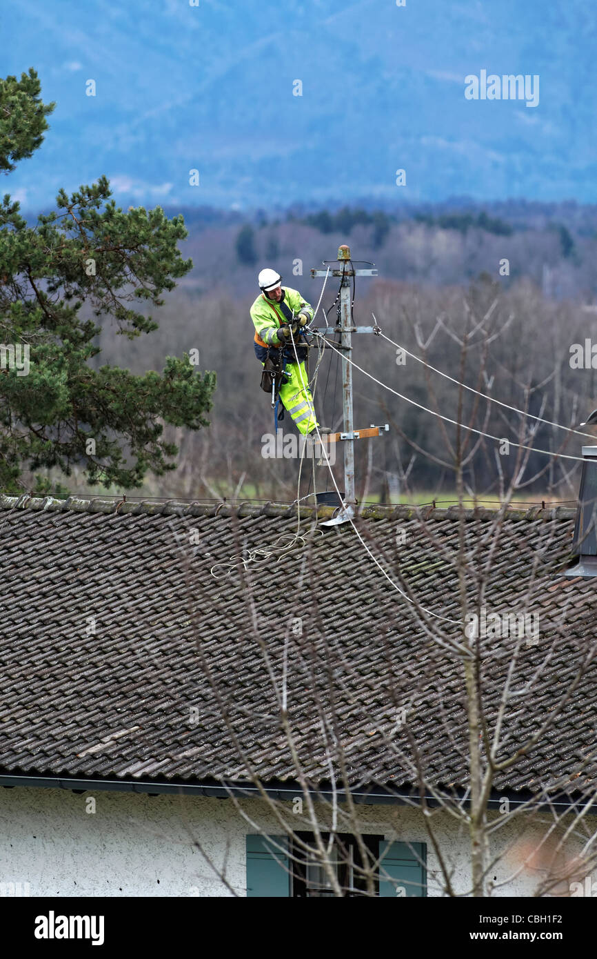 Elektrische Linienrichter auf einem Dach, die Installation von elektrischer Leitungen, obere Bayern Chiemgau Stockfoto