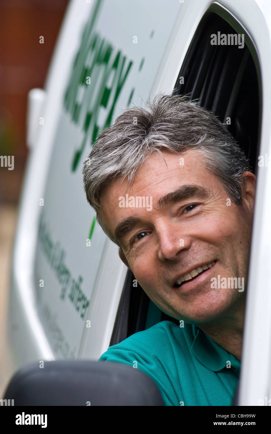 Lieferhandwerker Mann inländischer Anruf Service Wartung Lieferwagen Lieferungen Waren Impfstoffe Mann in einem kleinen weißen Lieferwagen lächelnd Stockfoto