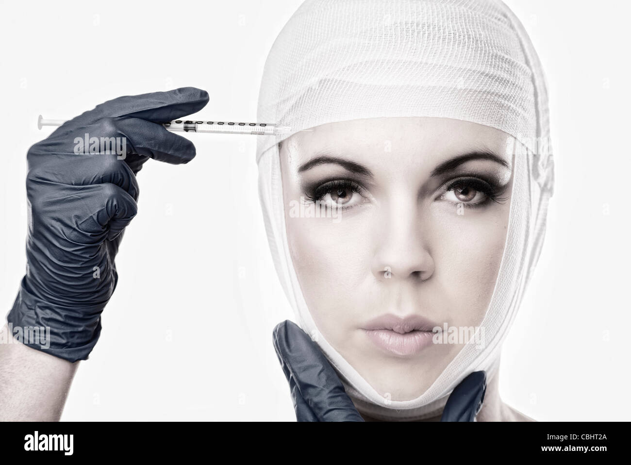 Frau mit bandagiertem Kopf etwa mit Botox injiziert werden Stockfoto