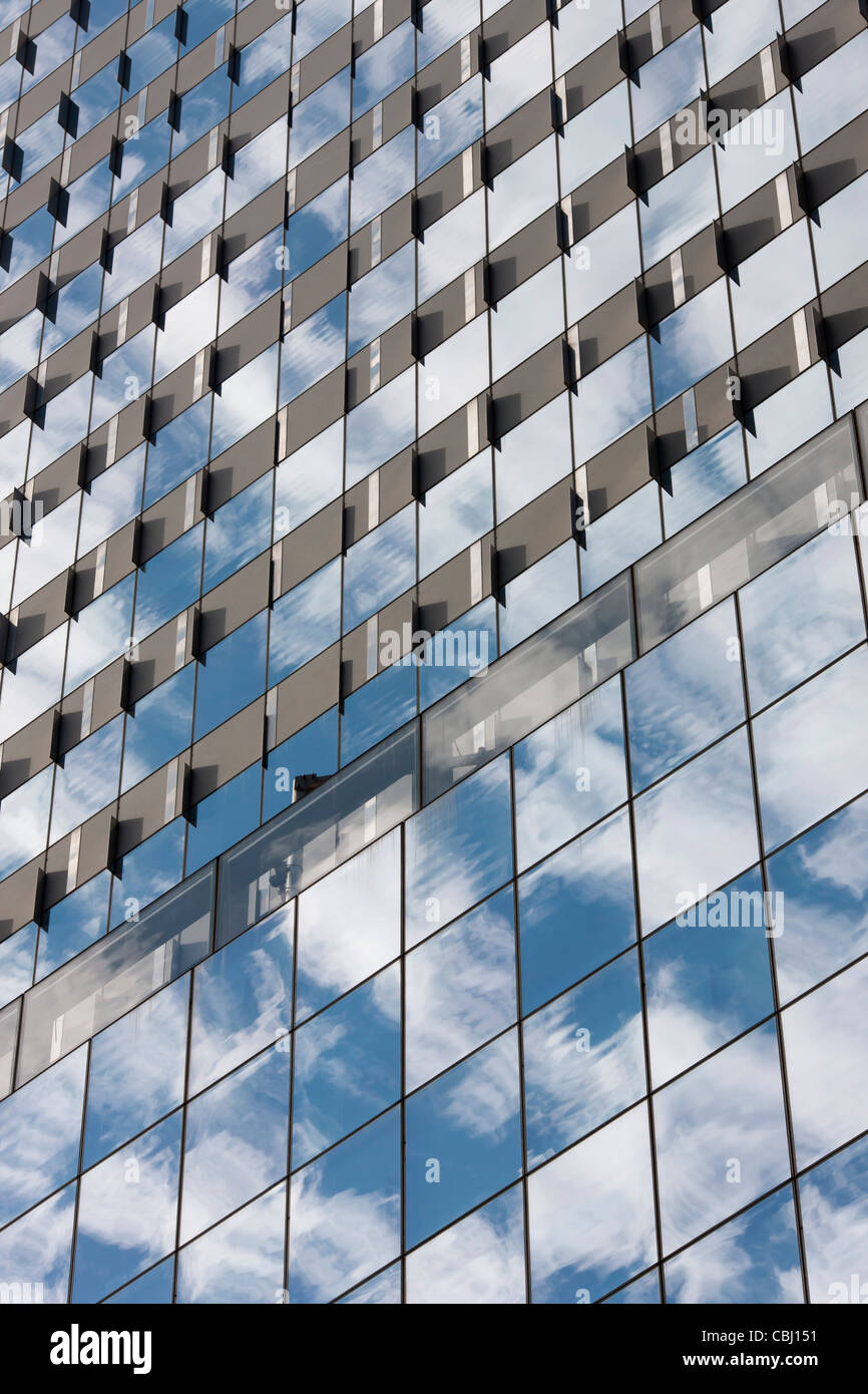 Himmel und Wolken spiegeln sich in den Fenstern eines modernen Gebäudes in New York City. Stockfoto