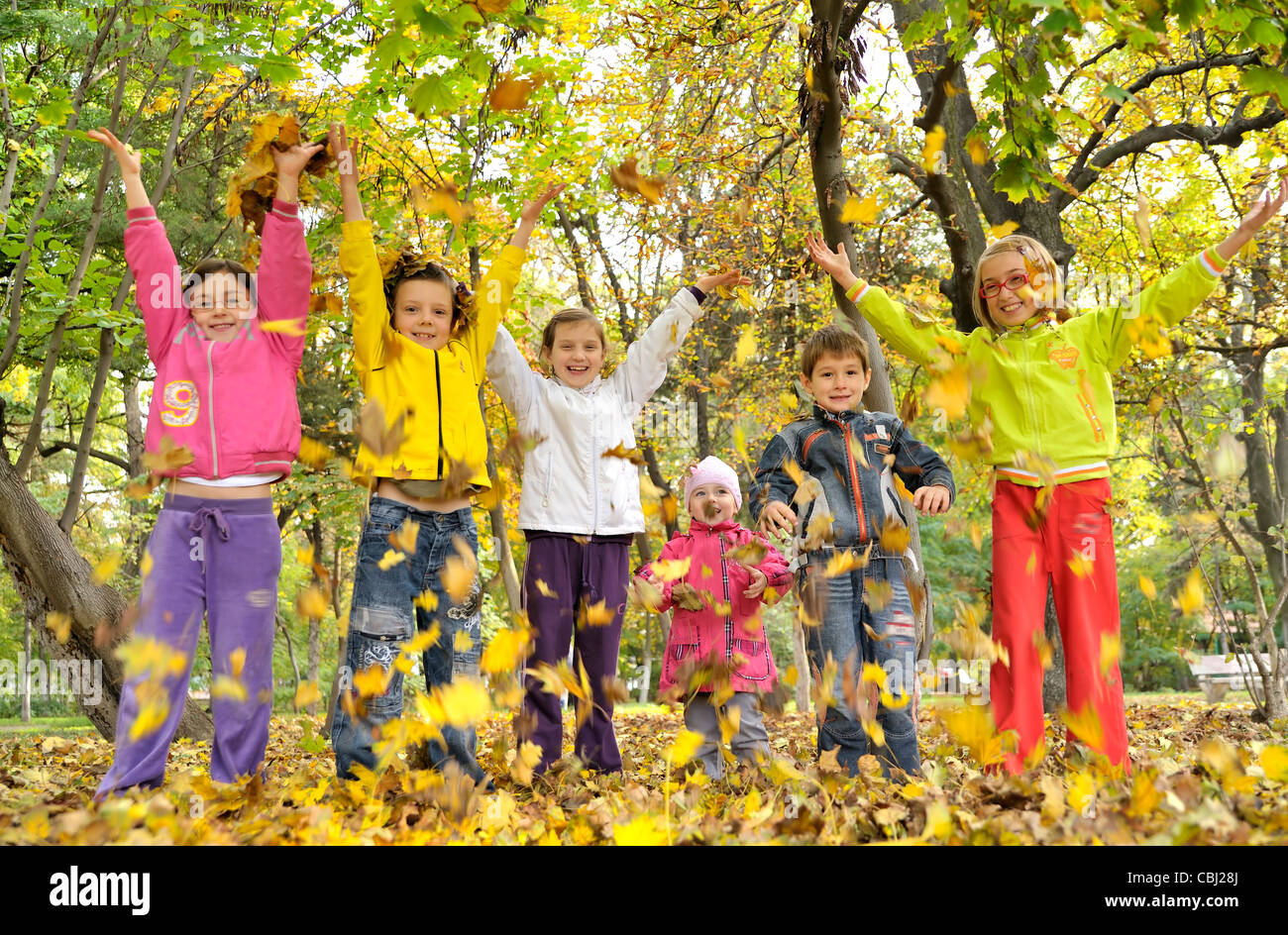 Kinder spielen mit Blättern Stockfoto