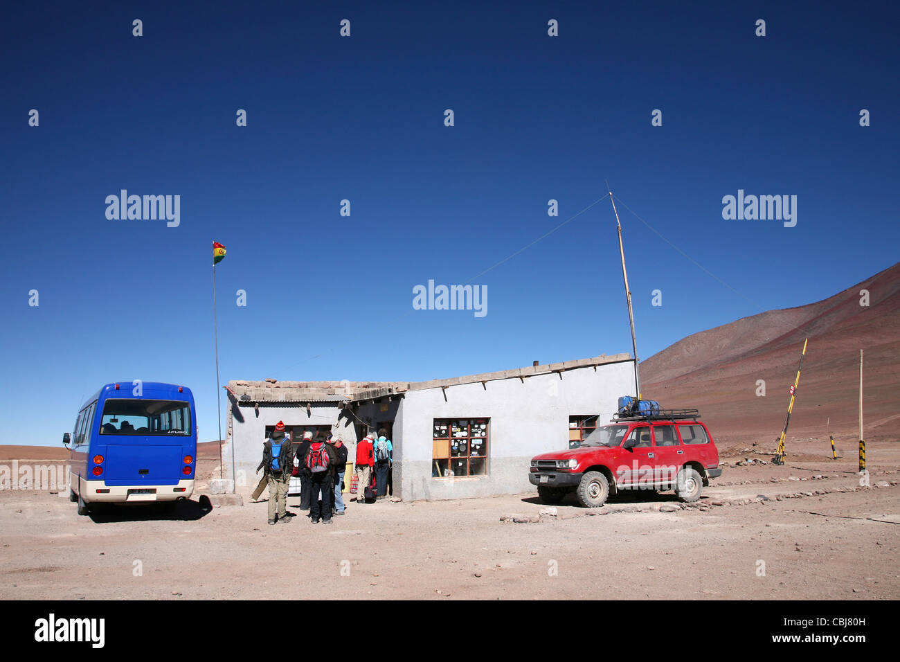 Fahrzeuge mit Allradantrieb und Touristen am offiziellen Grenzposten zwischen Chile und Bolivien Stockfoto
