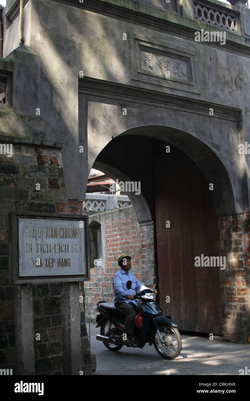 Mann auf dem Motorrad reiten vorbei an alten East Gate-Eingang zum alten Viertel von Hanoi Stockfoto
