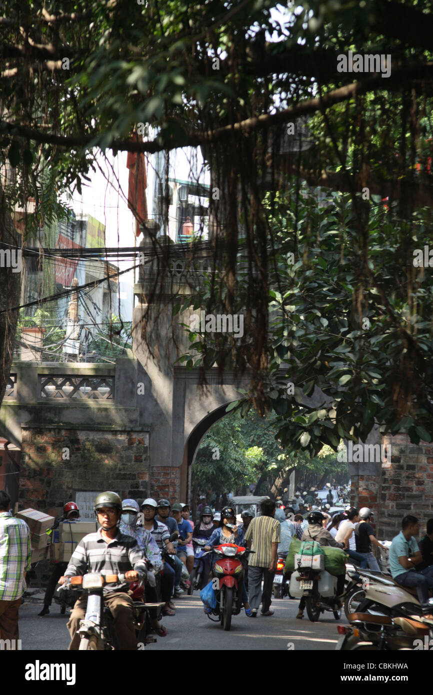 Motorräder, die Streaming-vorbei an alten East Gate-Eingang zum alten Viertel von Hanoi Stockfoto