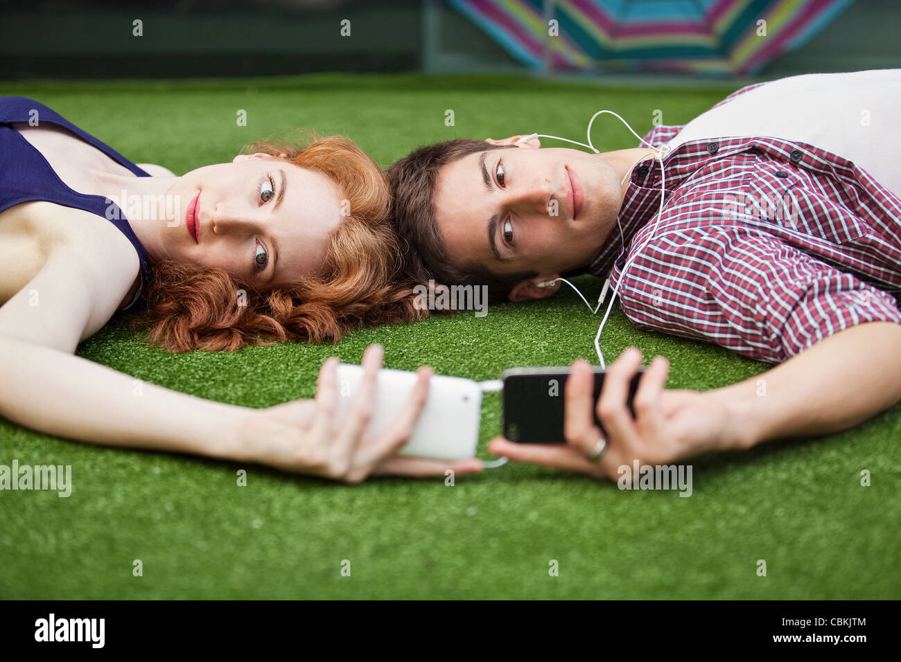 Paar liegend Blick auf Handys Stockfoto