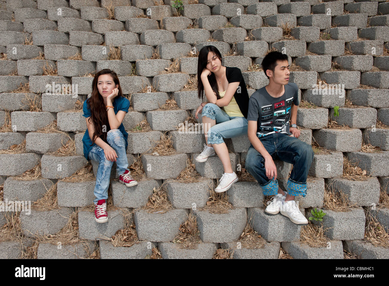 Junge Studenten sitzen auf die Betonsteine einen Deich Stockfoto