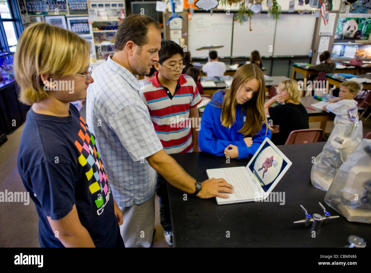 California Mittelschule Biologielehrer zeigt seinen Schülern eine E-Tour einen Frosch sezieren auf einem Laptopcomputer. Stockfoto