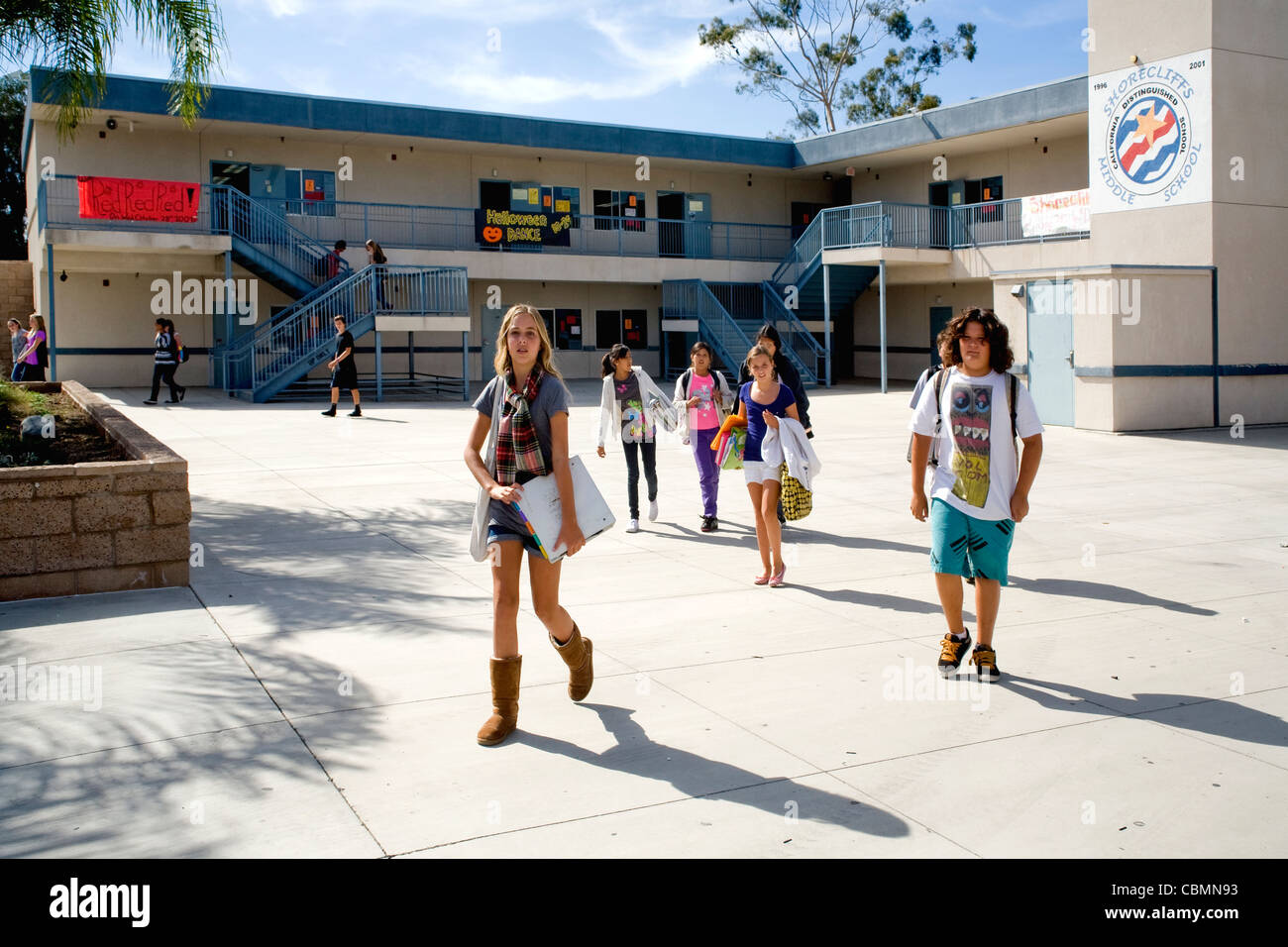 Kaukasische und Hispanic Mittelschüler / innen kreuzen ihren Schulhof in Südkalifornien. Stockfoto