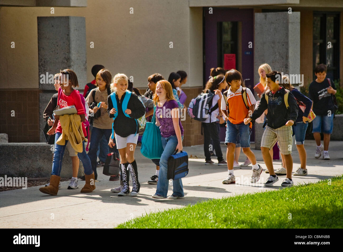 Eine multiethnische Gruppe von California Mittelschüler / innen kreuzen ihre Campus zwischen den Klassen. Stockfoto