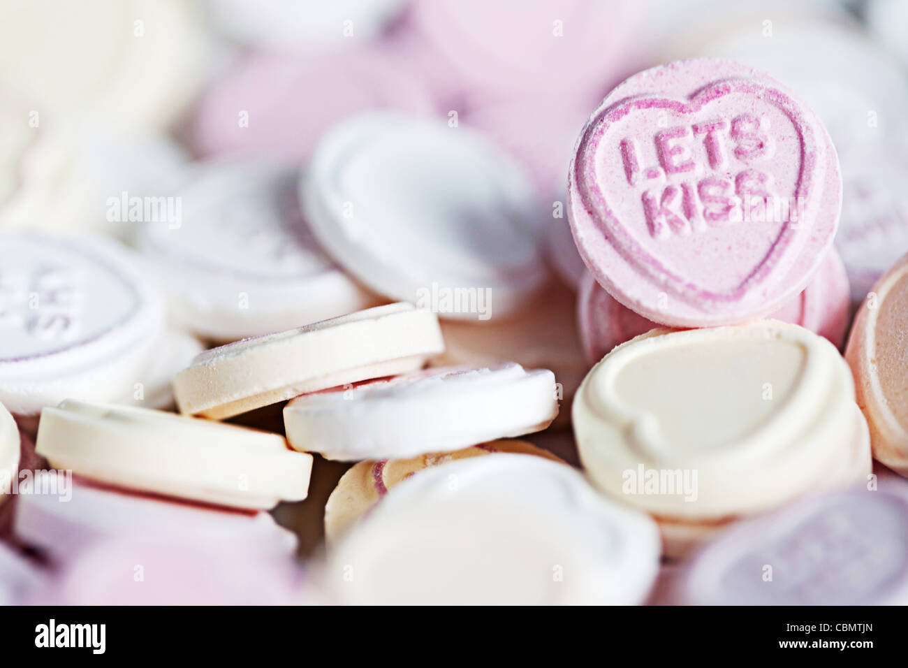 Kurz geschoren einer Schüssel Liebe Herz Süßigkeiten, mit Schwerpunkt auf die Nachricht "lets küssen" Stockfoto