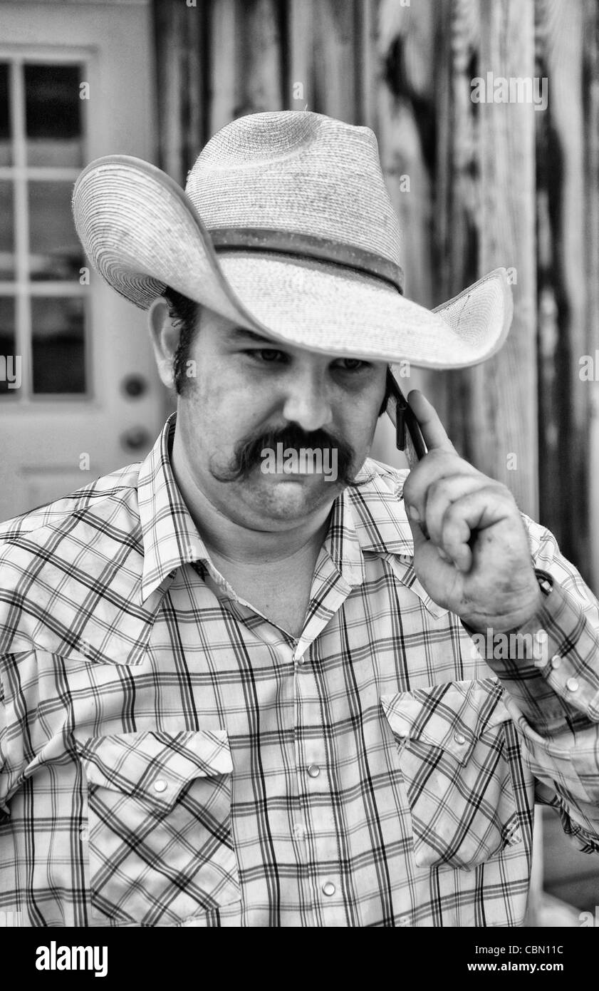 Das Leben eines Cowboys in den West USA als Cowboy Gespräche auf modernen Handy zu kommunizieren Stockfoto