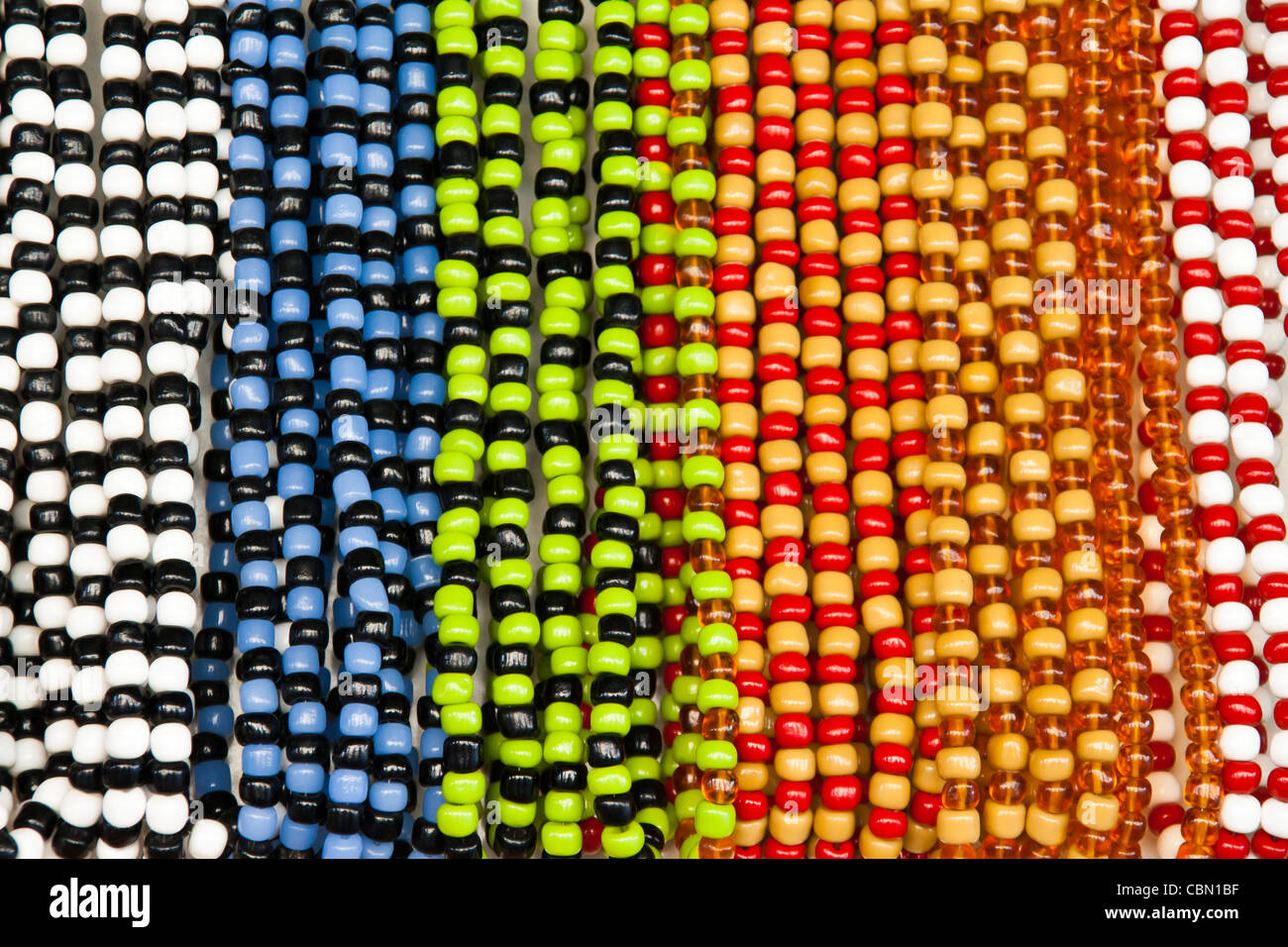 Verschiedene farbige Glasperlen hängen in einer Reihe Stockfoto