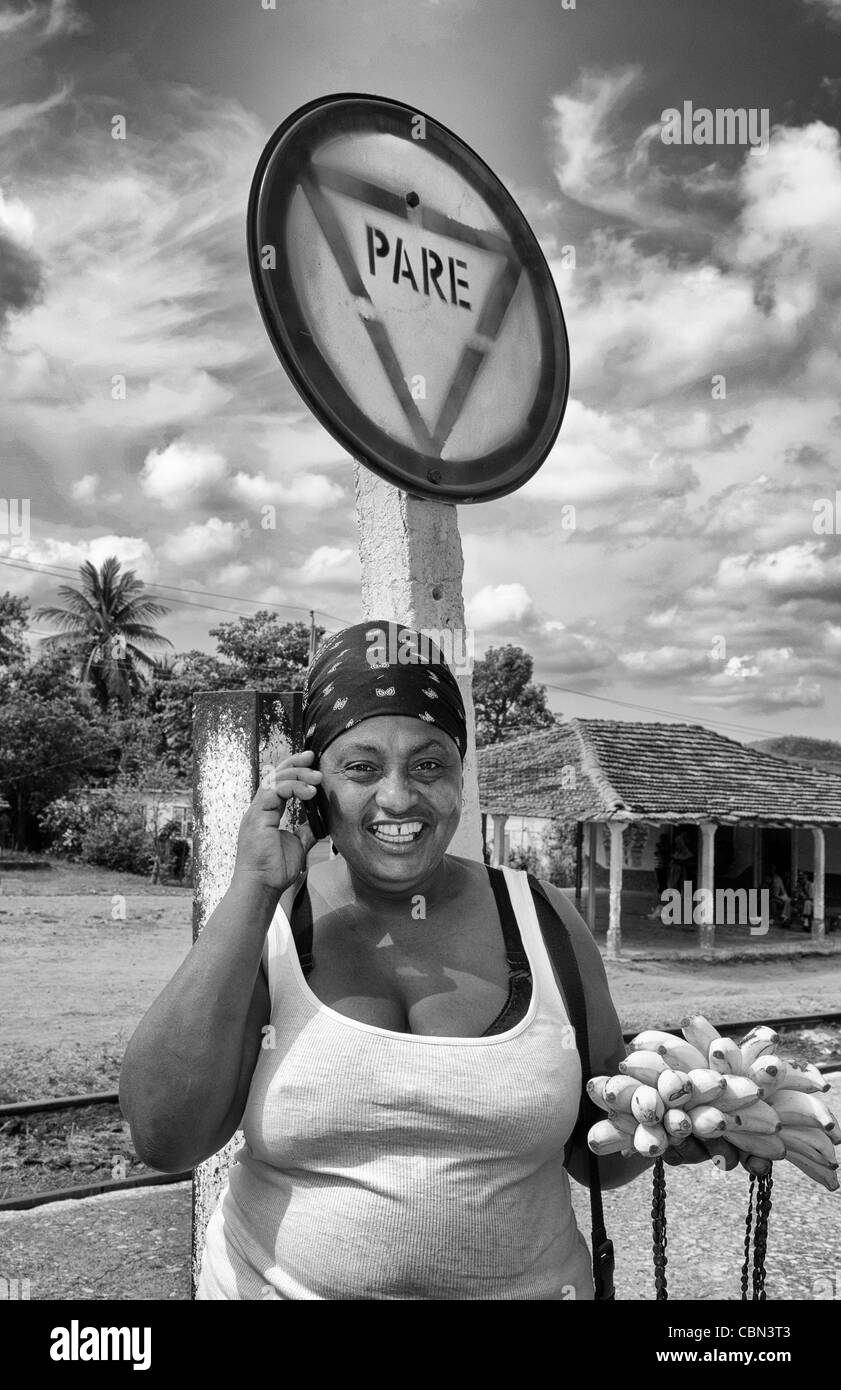 Lokale Frau am Handy im kleinen Dorf von Trinidad Kuba mit Stop-Schild Pare Stockfoto