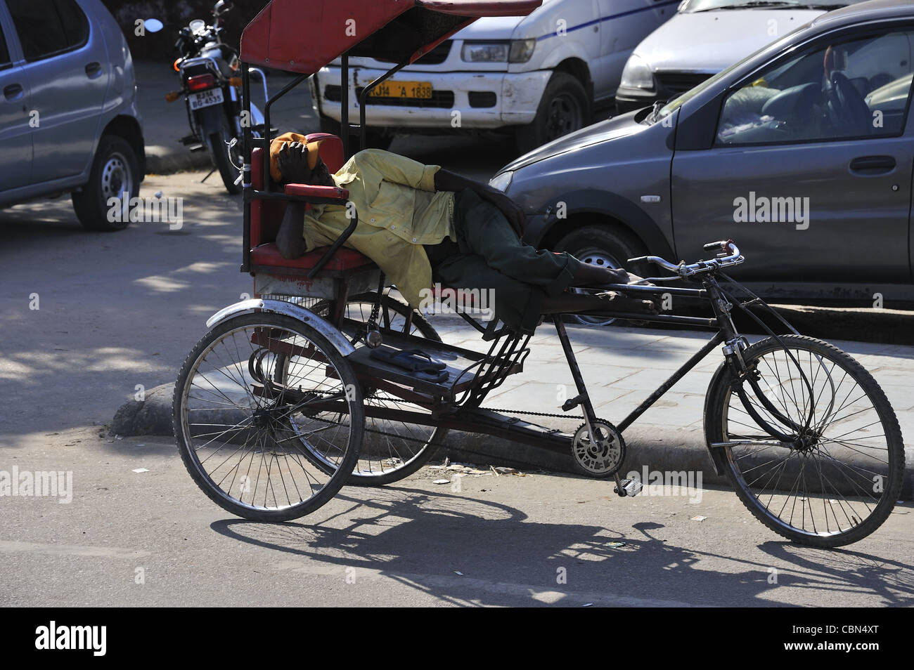 Fahrrad-Rikscha-Fahrer schlafen auf einer Straße in Agra Indien Stockfoto