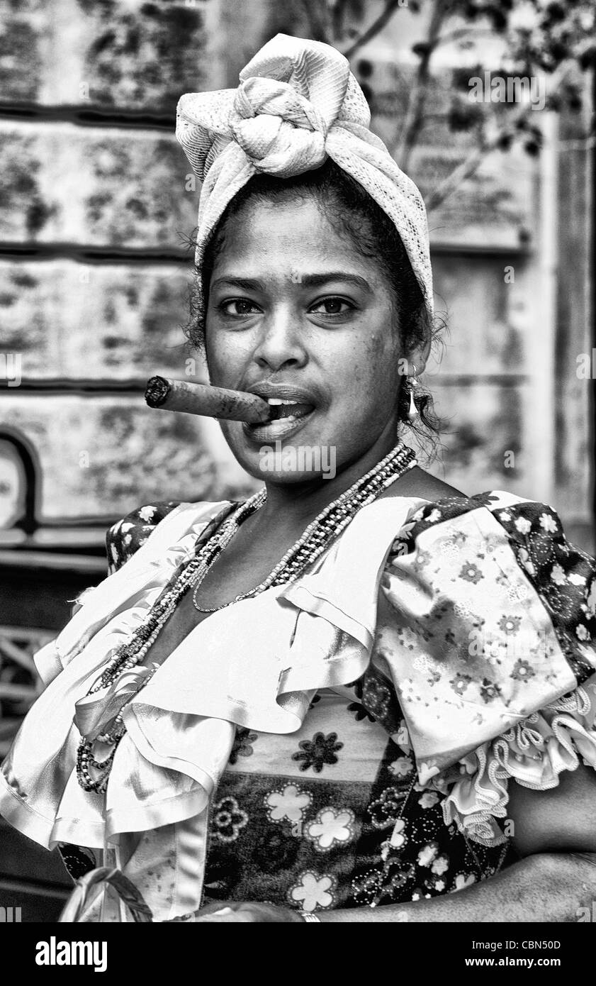 Bunte Frau in Tracht mit Blumen und Zigarre in Old Havana Habana in Kuba Stockfoto