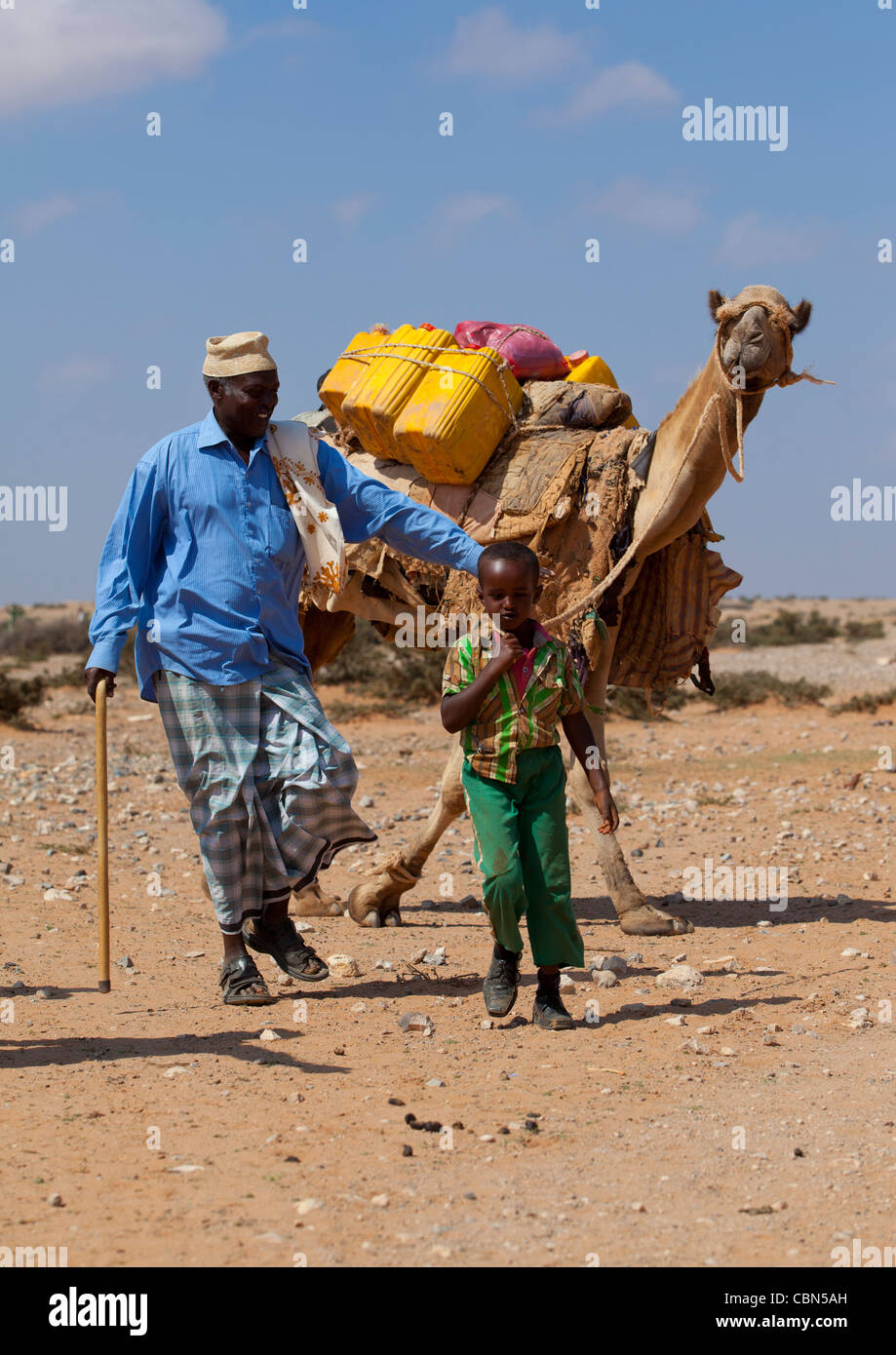 Mann und Youngster den Transport von Wasser auf einem Kamel zurück Dagabur Bereich Somaliland Stockfoto