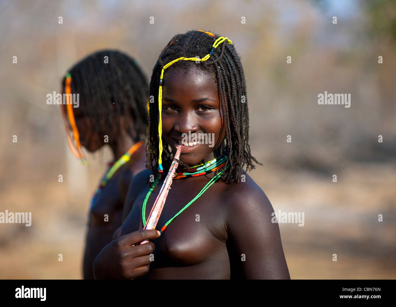 Mudimba Teenager-Mädchen knabbert ein Stück Stoff, Dorf Combelo, Angola Stockfoto