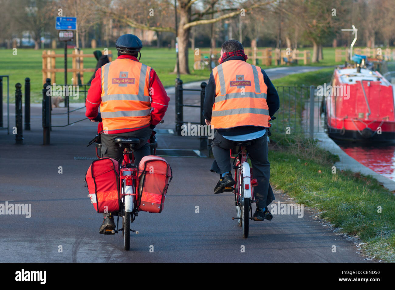 Zwei Briefträger mit ihren Fahrrädern entlang des Flusses Cam in Cambridge. England. Stockfoto