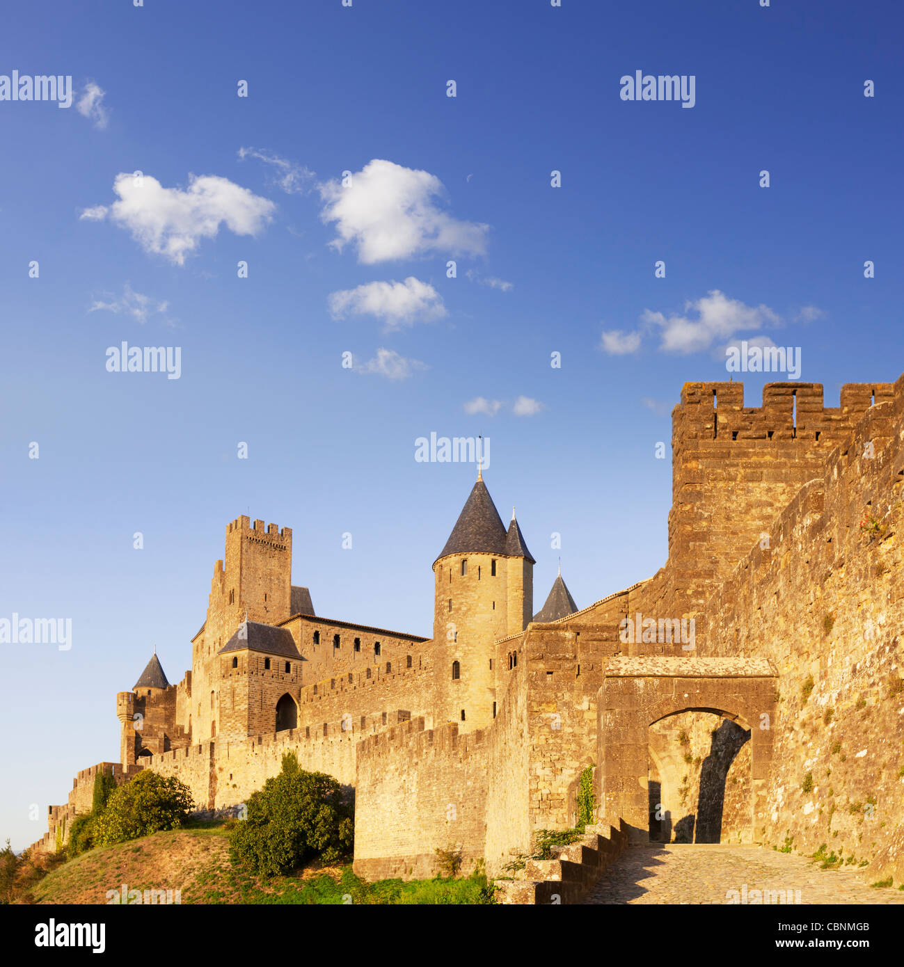 Die Annäherung an die Porte d'Aude in Carcassonne, mit dem Schloss hinter sich, am Abend. Stockfoto