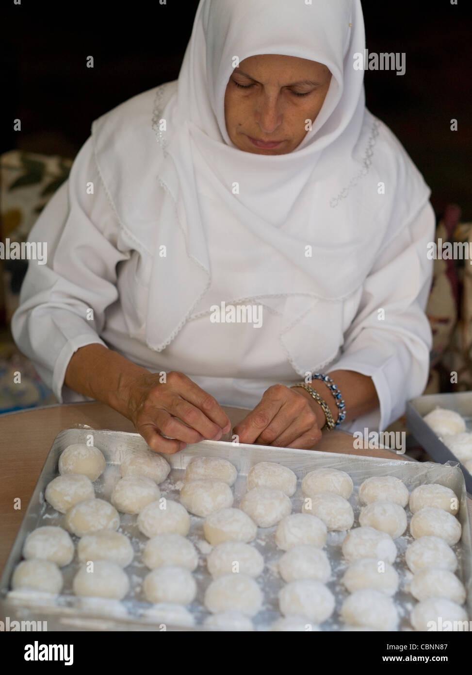Türkische Frau in weiß mit Kopftuch Brotbacken Stockfoto
