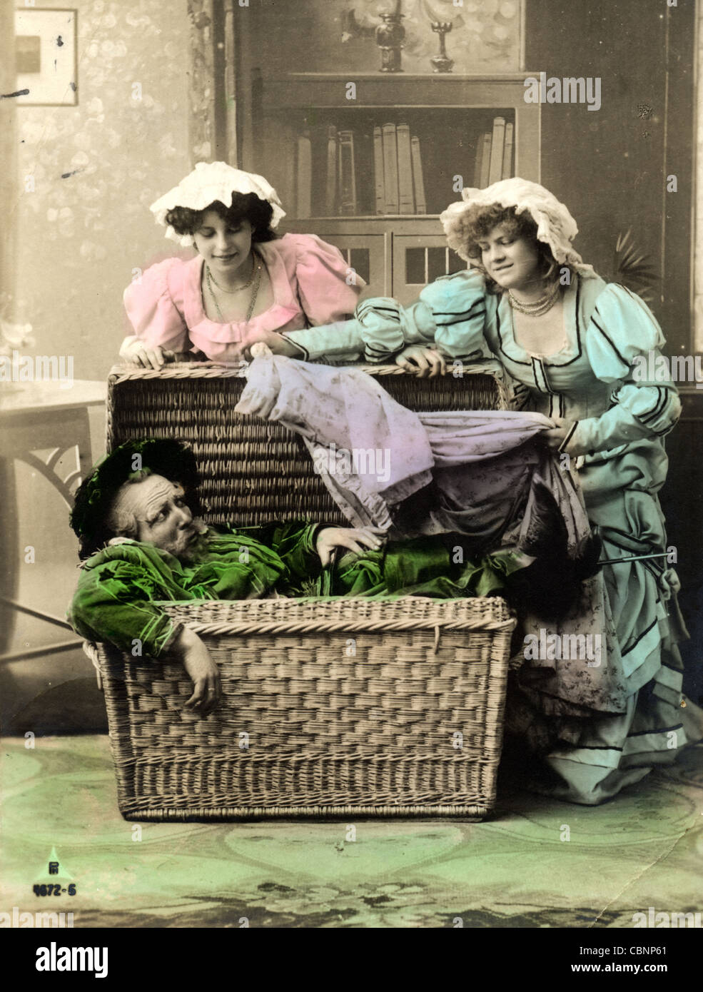 Zwei junge Frauen packen Greis im Steamer Trunk Stockfoto