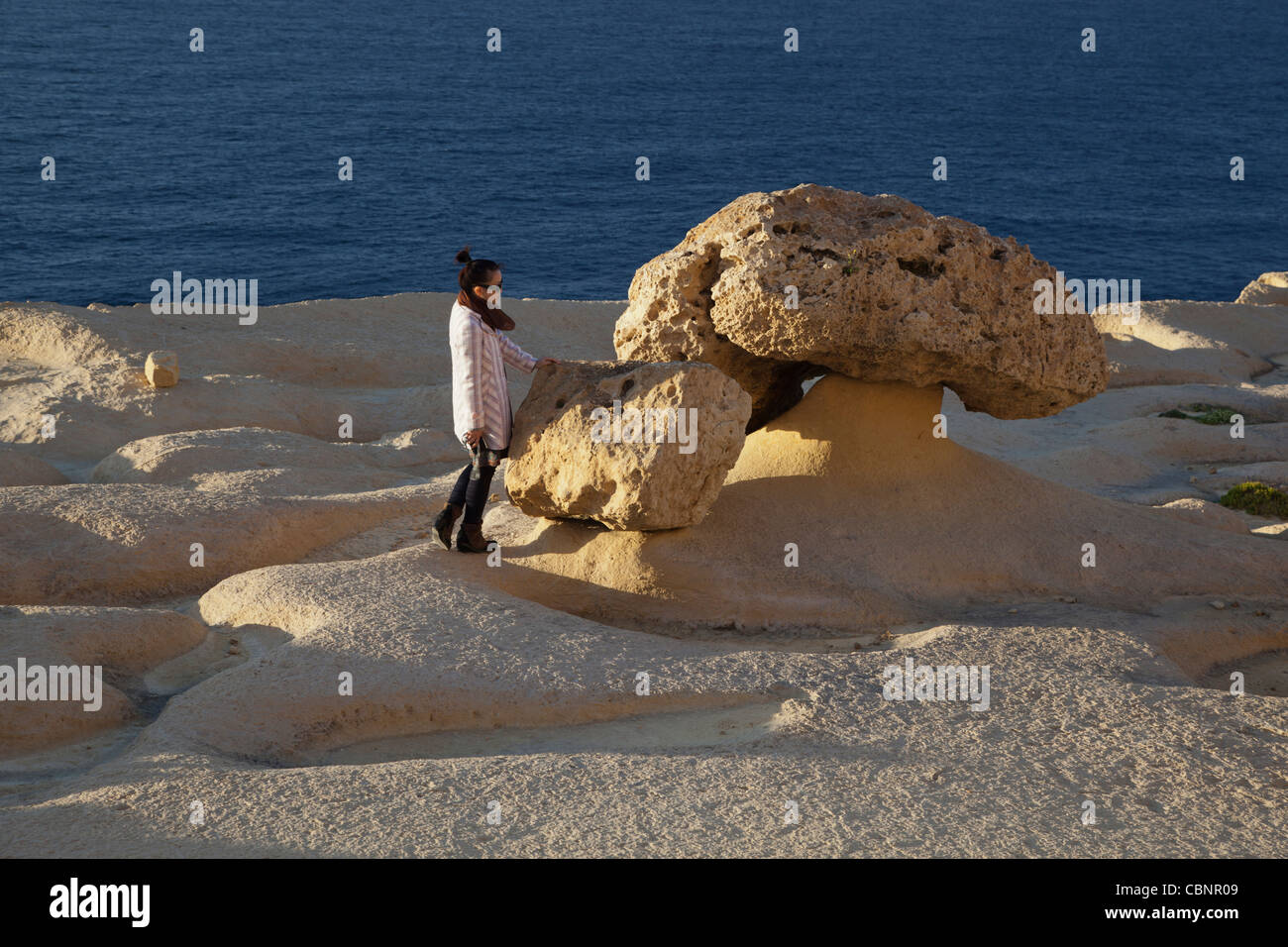 Ein Findling von Hartgestein links gestrandet wie weicher felsigen Kalkschicht unter mit Wind & Wasser in Malta erodiert ist. Stockfoto