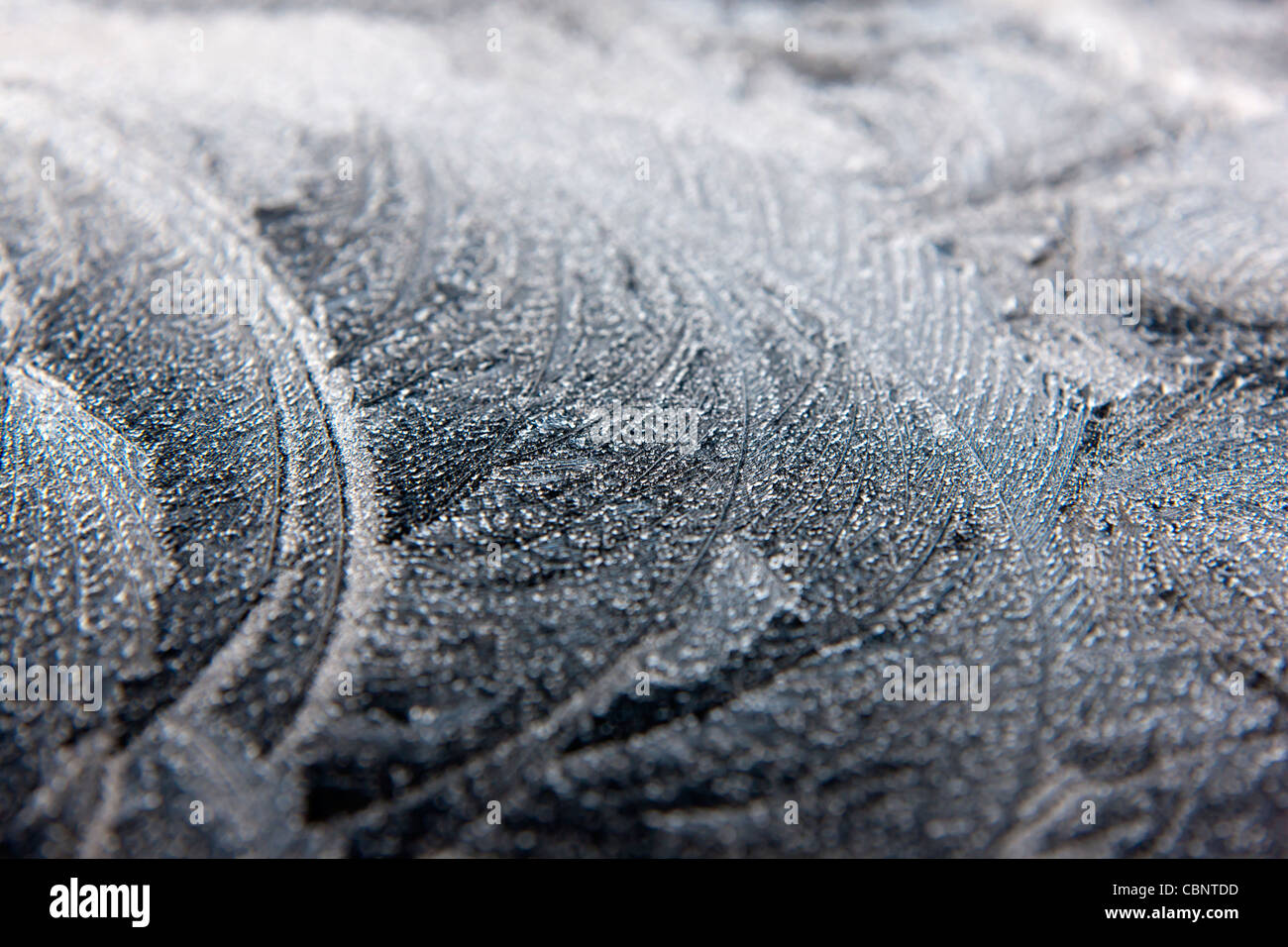 auftretende kristalline anorganische feste Eiskristalle Frost auf einer Fensterscheibe gefrorenes Wasser transparent opak Stockfoto