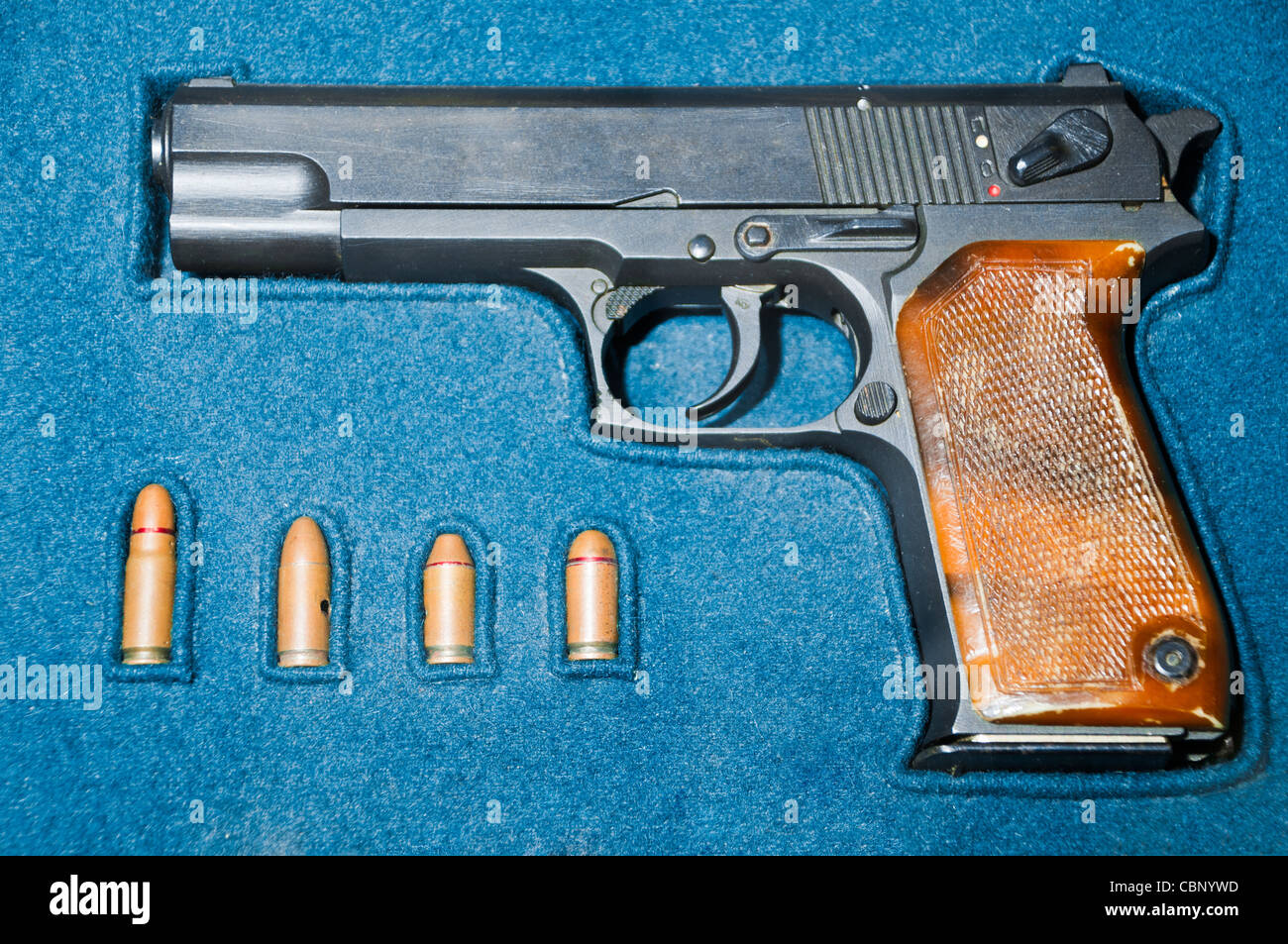 Pistole und vier Kugeln in blauen Kästchen Stockfoto