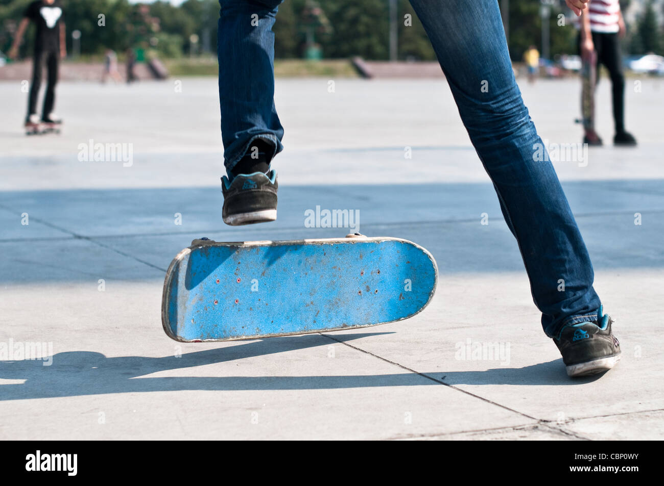 junge Skater segelnder Stunt auf seinem blauen Brett Stockfoto