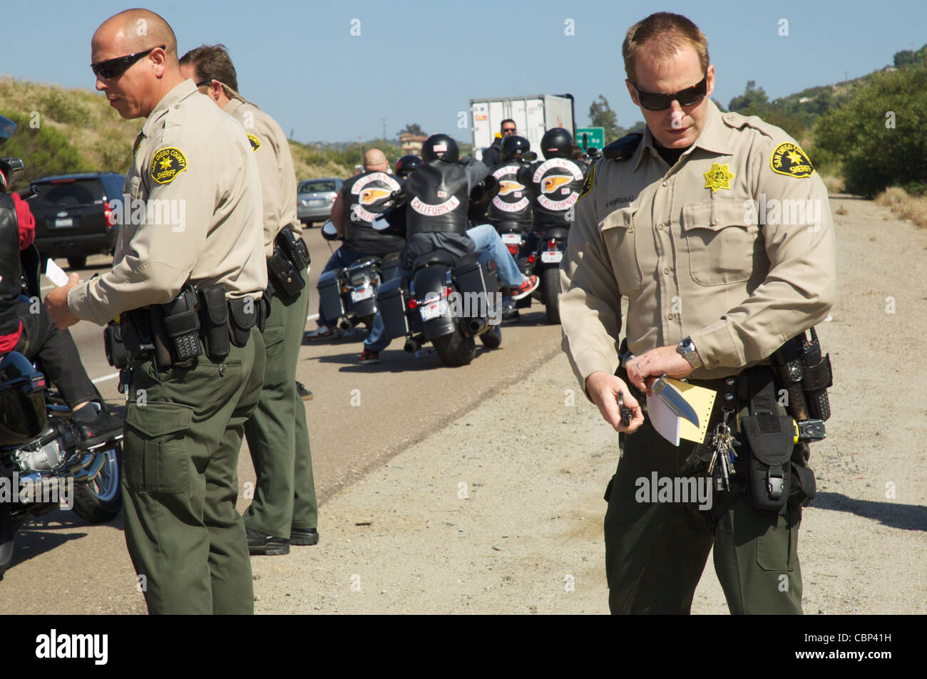 Ein Sheriff Stellvertreter aus dem San Diego Sheriff Department sichert ein Messer, das aus einem Hells Angel, während ein Verkehr entfernt wurde Stockfoto