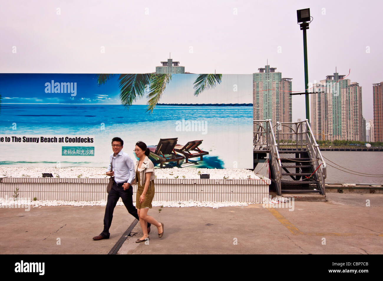Ein chinesisches Ehepaar vor einer Werbung für Sonnenstrand - Shanghai (China) Stockfoto