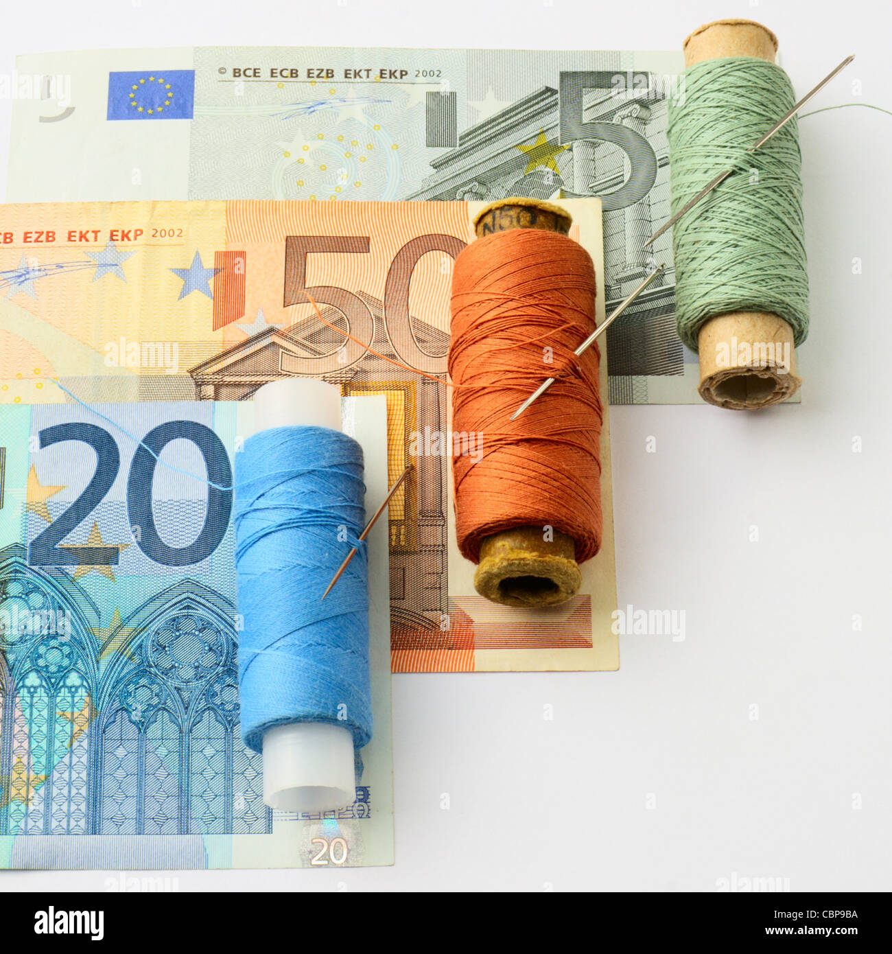 Сoncept. Renovierung des europäischen Finanzsystems. Farbigen Fäden und eine Nadel für die Reparatur von Euro Stockfoto