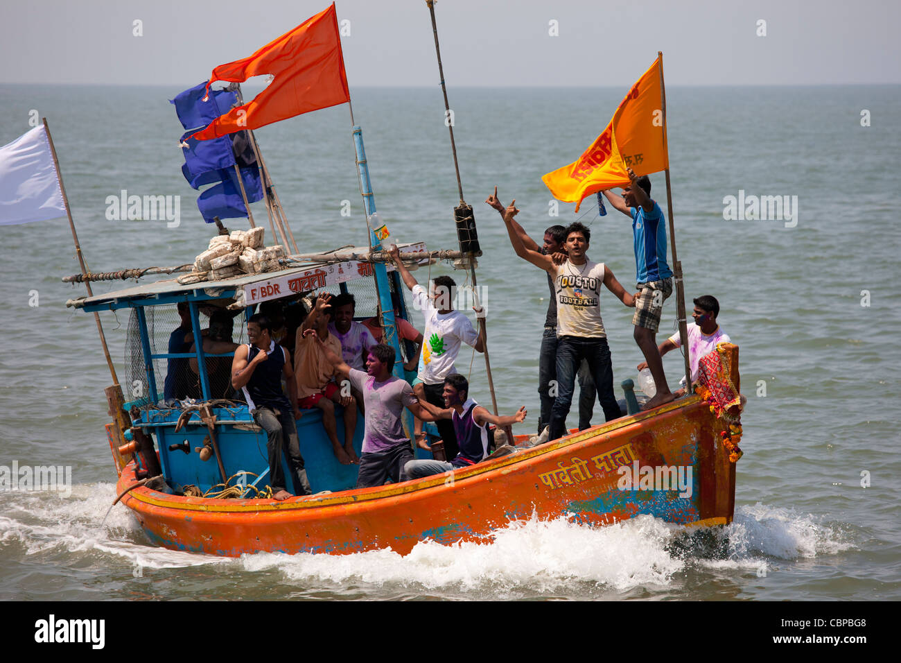 Junge indische Männer auf Bootsfahrt feiert hinduistischen Holi-Fest der Farben am Nariman Point in Mumbai, ehemals Bombay, Indien Stockfoto