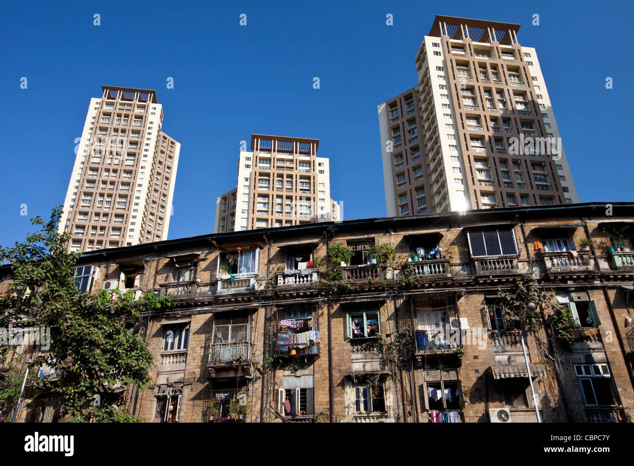Alte traditionelle Mietshaus wohnen im Schatten des neuen modernen high-Rise Wohnblöcke am Mahalaxmi in Mumbai, Indien Stockfoto