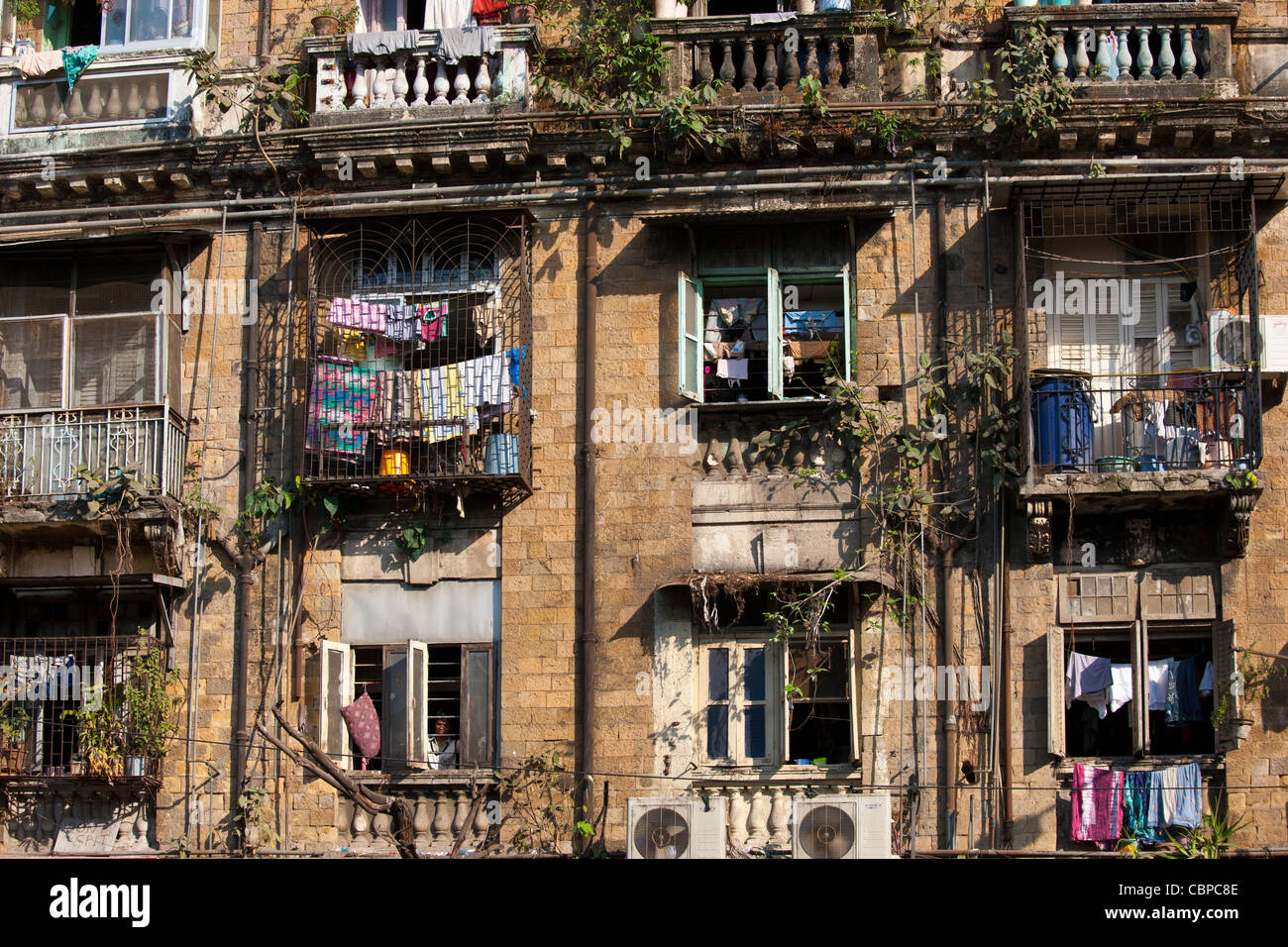 Tenement Block traditionelle Chawl Siedlung mit Klimaanlagen und Mann im Fenster im Bereich Parel Mumbai, Indien Stockfoto