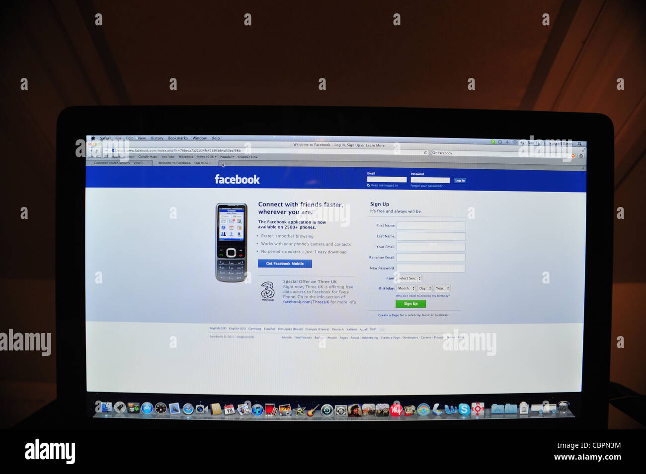 Facebook-Seite zu öffnen, auf Computer-Monitor in abgedunkelten Raum Stockfoto