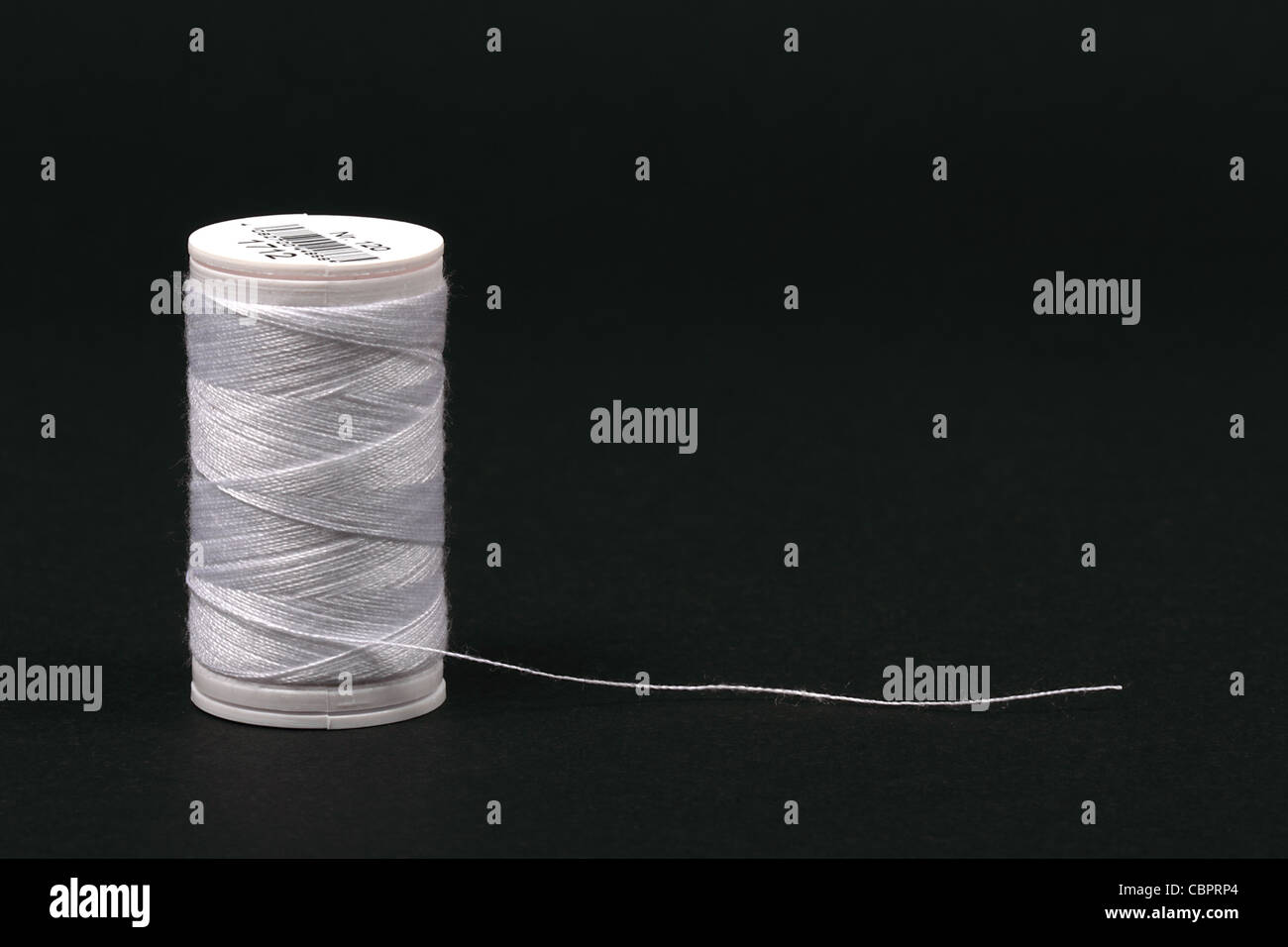 weiße Nähgarn auf dem schwarzen Hintergrund Stockfoto