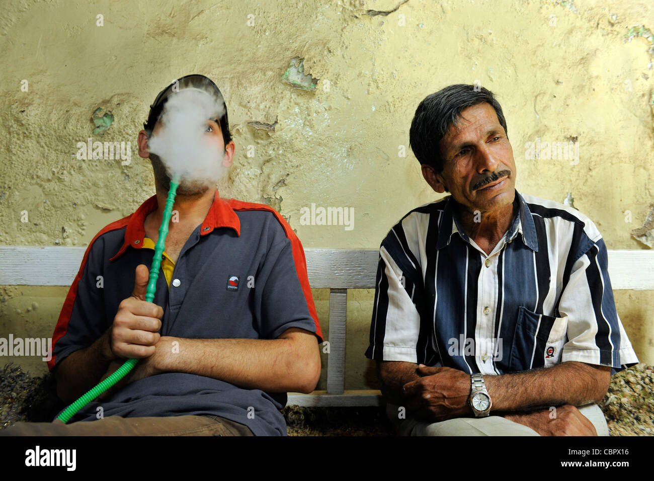 Ein Rauch in einem traditionellen Teehaus (Chai) mit eine über 500 jährige Geschichte in Bagdad, Irak. Stockfoto